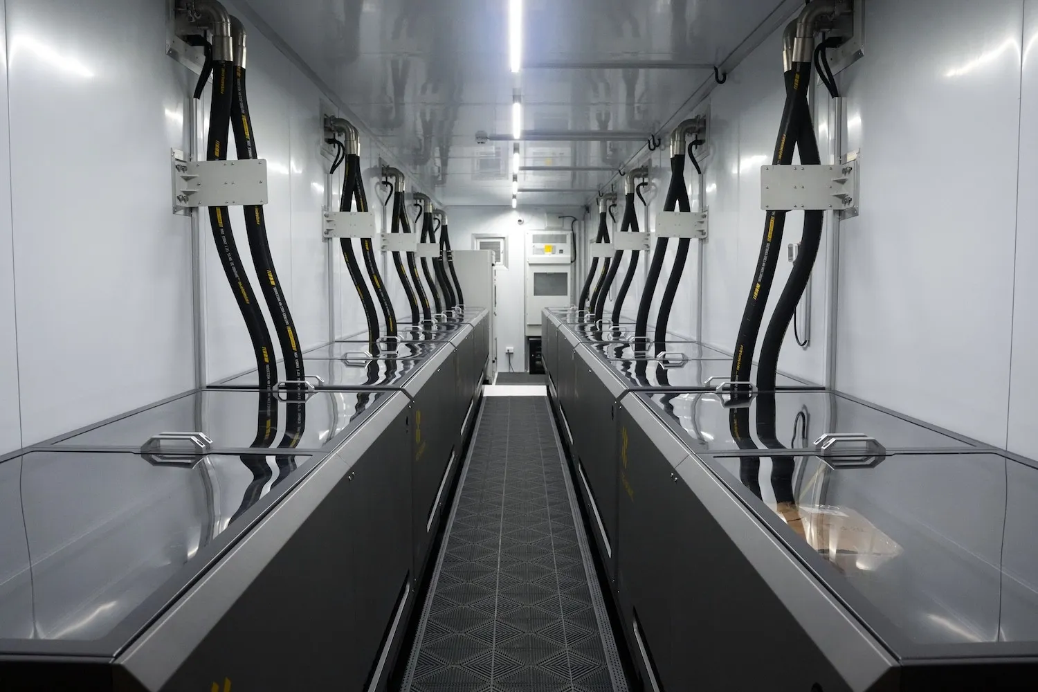 Container interior aisle lined with immersion tanks and overhead cabling