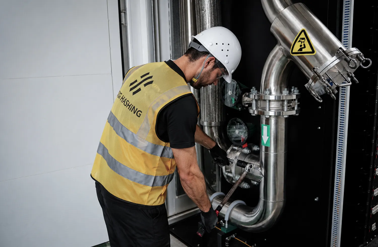 A Fog Hashing technician torquing a coolant loop flange during factory acceptance testing