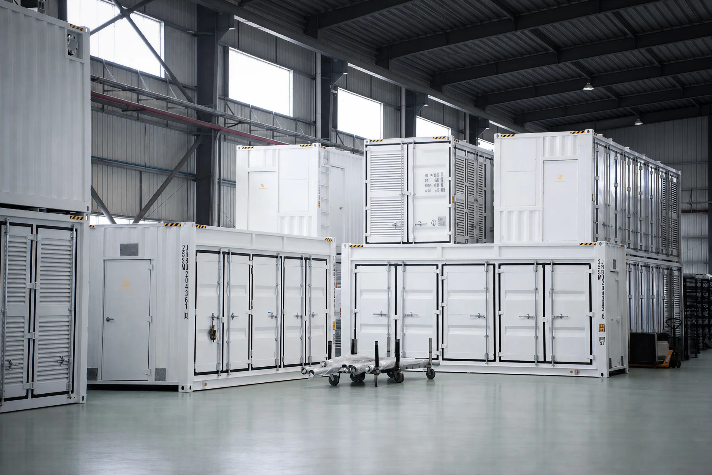 Finished container modules staged on the factory floor, stacked two high down the bay