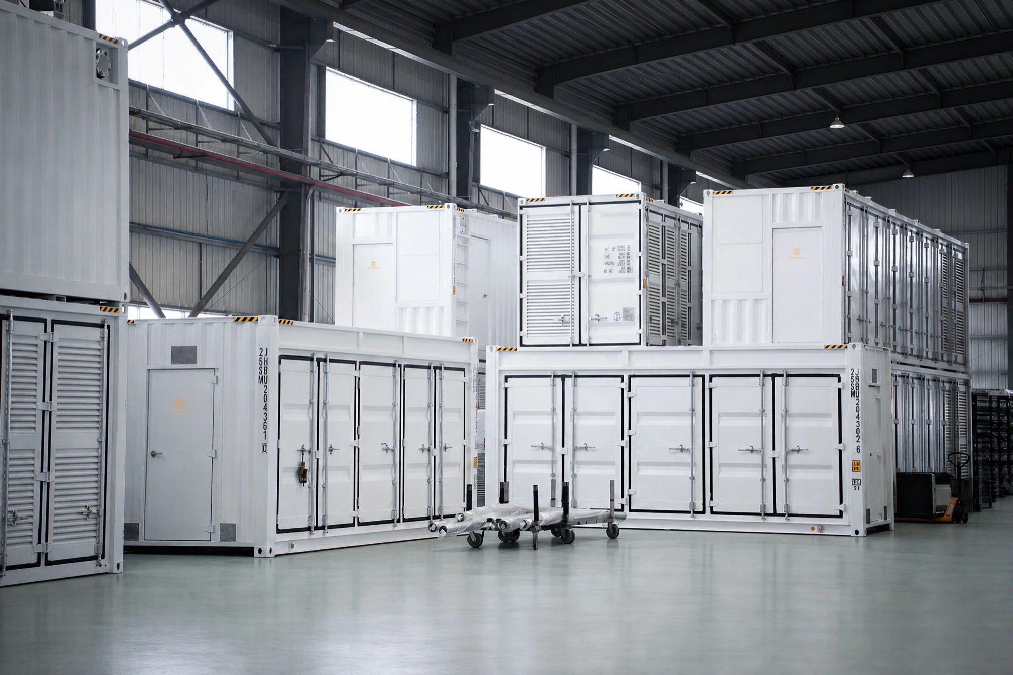 White container modules staged and stacked on the Fog factory floor, doors closed for dispatch