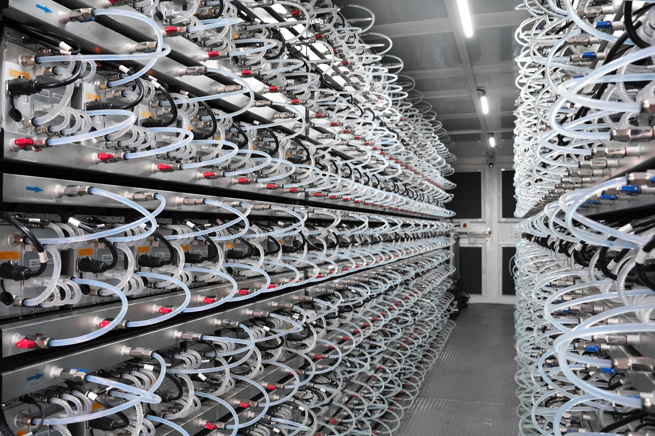 Interior aisle with coolant hoses looped to every miner on both walls