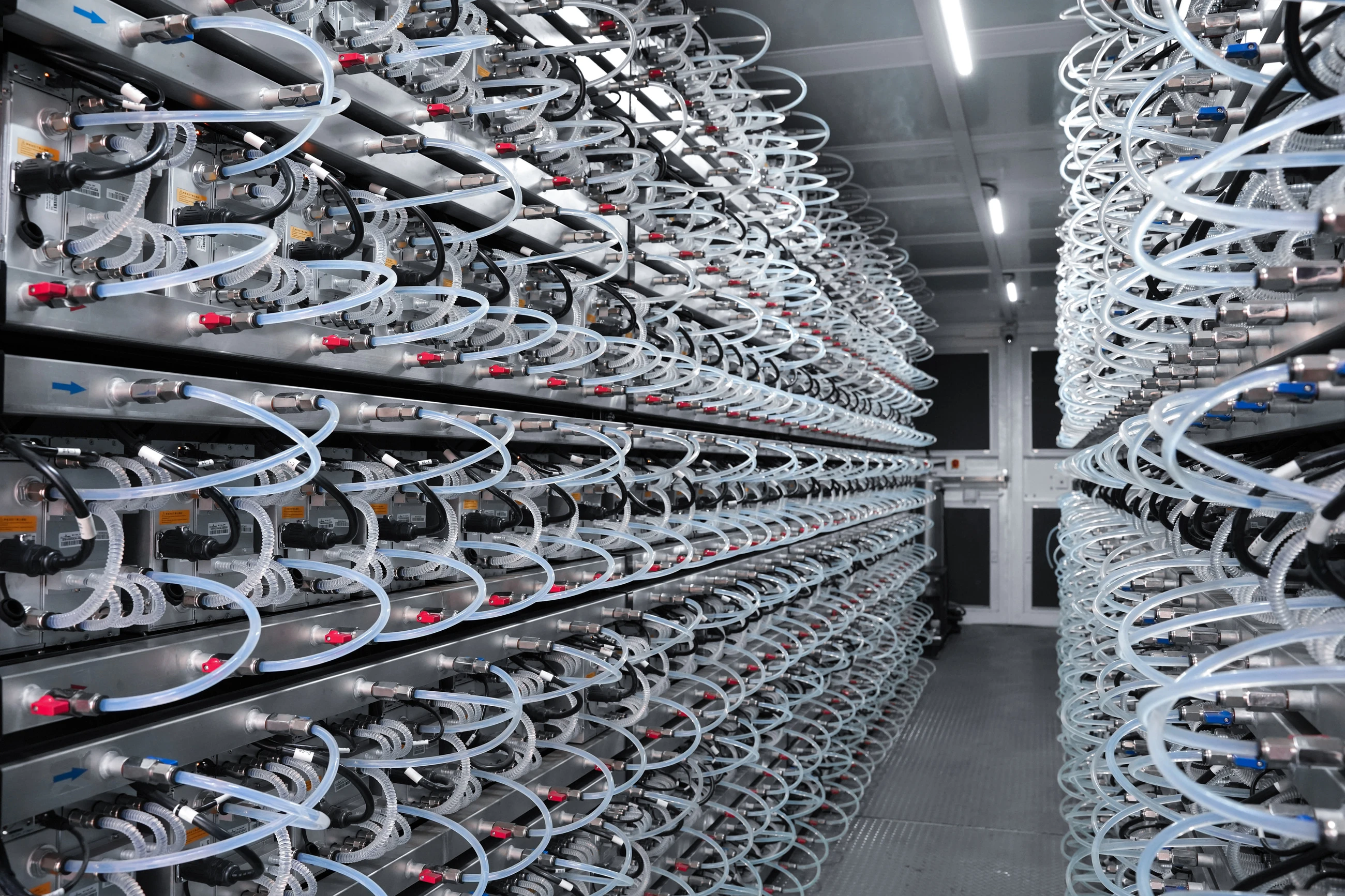 Interior aisle with coolant hoses looped to every miner on both walls