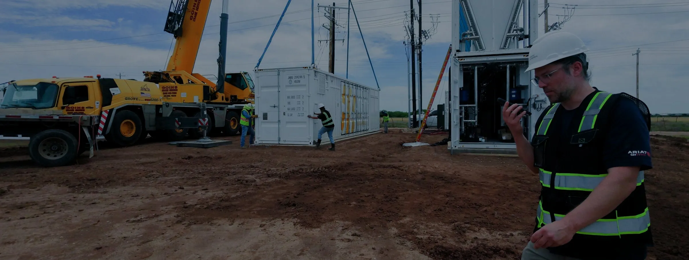 A Fog module being craned onto its pad, crew and switchgear in frame