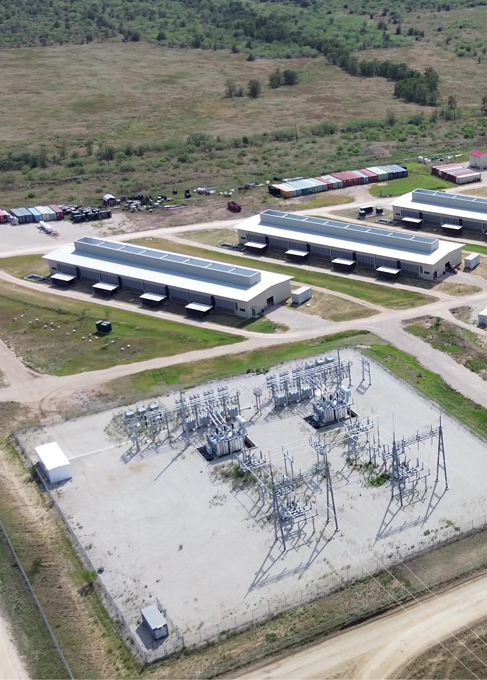 Aerial of a powered site: the substation in the foreground, the compute buildings it feeds behind