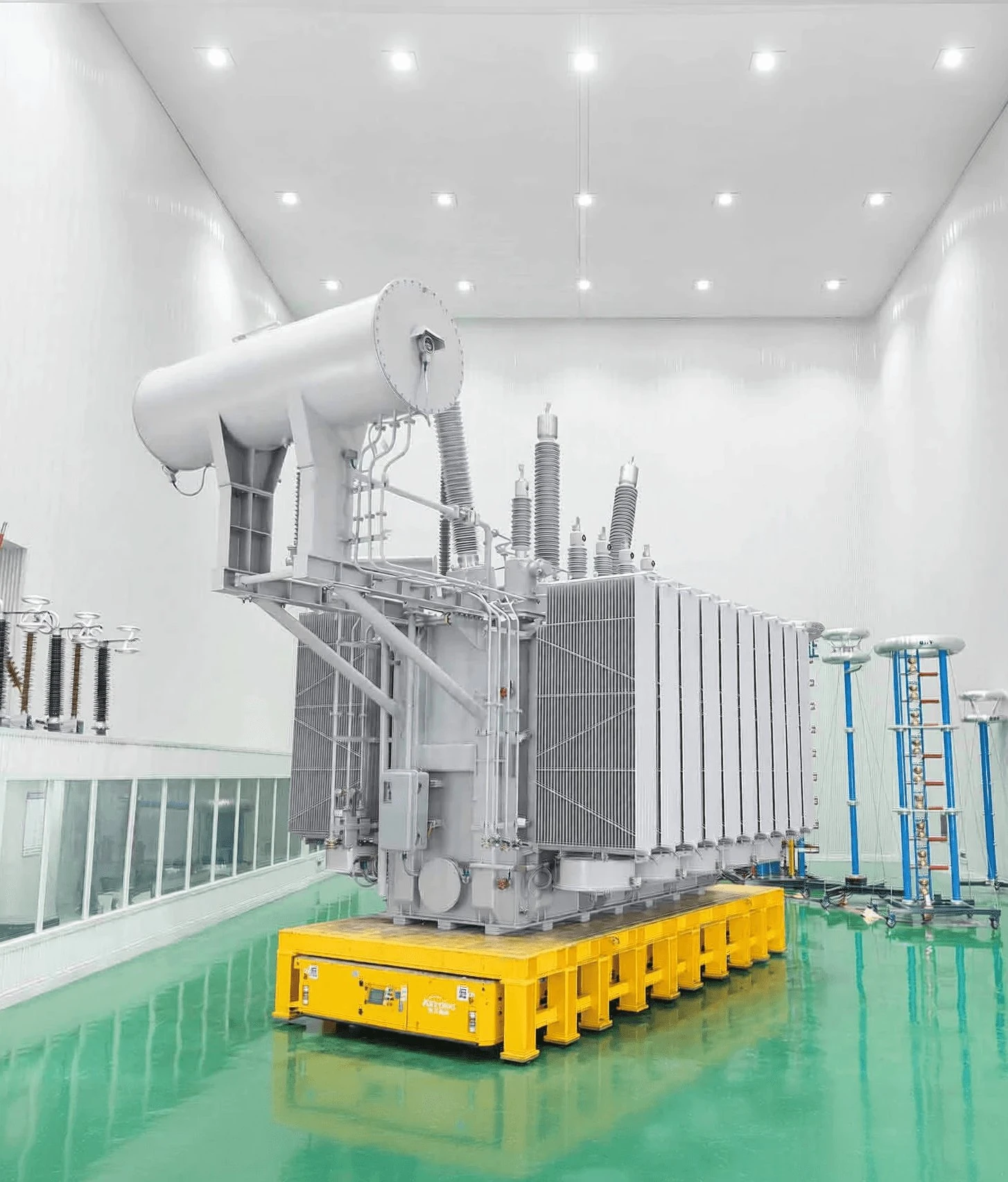 A utility-scale transformer on a transporter inside the assembly hall