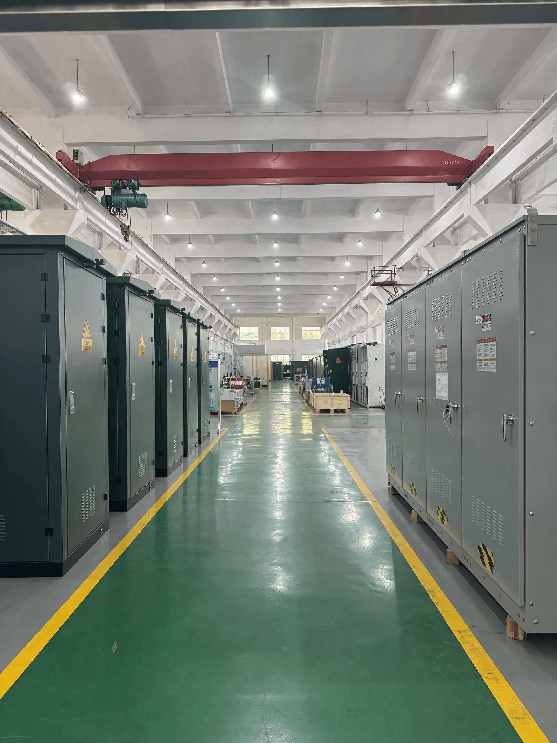 Finished switchboard sections lined up down the factory aisle