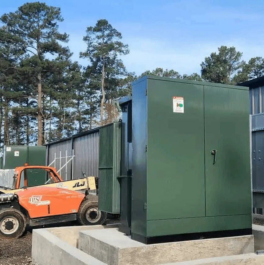 A pad-mount transformer set on its pad at a live site